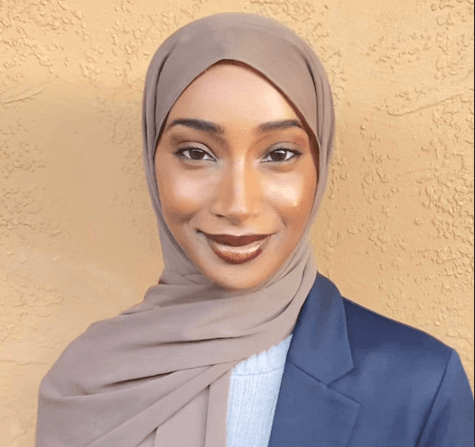 Headshot of Rahma, a woman wearing a purple headscarf, grey shirt and navy blue blazer.